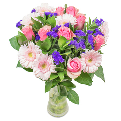 As I craft this arrangement in the heart of Sands End, every bloom reflects the gentle character of the neighbourhood. Soft pink roses, each petal like a brushstroke of affection, mingle with luminous blush gerberas to create a bouquet that feels both fresh and graceful. Delicate spires of deep purple statice peek through, adding lively punctuation and a touch of wildness reminiscent of the weekend flower stalls near Imperial Wharf. The lush, cool greenery grounds the entire composition, bringing with it a sense of abundance and the subtle scent of shaded mews gardens. Arranged in a clean, slender glass vase, the flowers are set aglow by the soft north London light, their pastel hues effortlessly blending together like the morning sky over Sands End Park. The bouquet's airy yet intricate design conveys optimism-perfect for celebrating special moments or offering warmth to someone's day. Whether it's a thoughtful get-well wish, a cheerful greeting for a friend in Chelsea Creek, or a graceful touch for a local dining table, this bouquet represents the Florist Sands End dedication to careful artistry and the joy of community connections. Every detail, from the just-unfurling rose to the playful flicker of statice, speaks of quality and care, making it a heartfelt gift for any occasion.