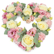 A lush, heart-shaped funeral tribute is shown in full view, suspended against a spotless white background so that its pastel colours appear extra soft and luminous. The heart is meticulously formed from an abundance of creamy ivory and pale yellow roses, each bloom perfectly shaped, their petals layered in tight spirals that gradually open into rounded cups. Nestled around them, clusters of light pink carnations provide a rich, textured fill, their frilled edges touching like delicate lace and giving the design a comforting, cushioned effect. Scattered amongst this softness are deeper pink and mauve lisianthus flowers, some more open and trumpet-like, others in gentle bud form, bringing depth and a slightly more contemporary note to the classic rose-and-carnation pairing. Silvery-green eucalyptus leaves weave in and out of the blooms, their smooth, rounded foliage curving along the heart's outline, lending a cool, calm balance and a hint of fresh, herbal scent. Tiny yellow-green buds pierce the pastels with little sparks of vitality, suggesting freshness and careful, same-day preparation typical of a dedicated local florist serving Sands End. The composition is full and symmetrical, with no gaps, so the heart looks complete and reassuring-an emblem of enduring love and cherished memories. This floral heart would make a moving tribute at a funeral, memorial, or celebration of life held for families in and around Sands End, whether placed by the casket, on a stand near the altar, or beside a framed photograph, offering a quiet, visual expression of sympathy, comfort, and remembrance.